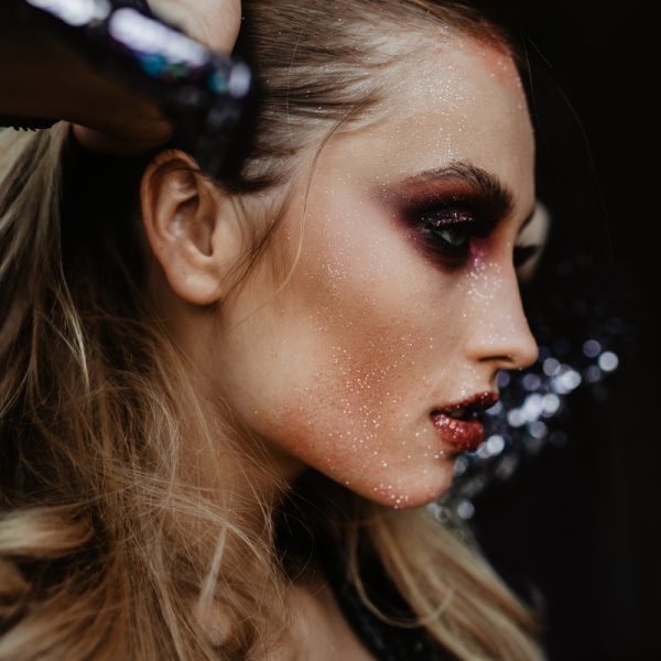 jeune femme blonde portant un maquillage de soirée sombre