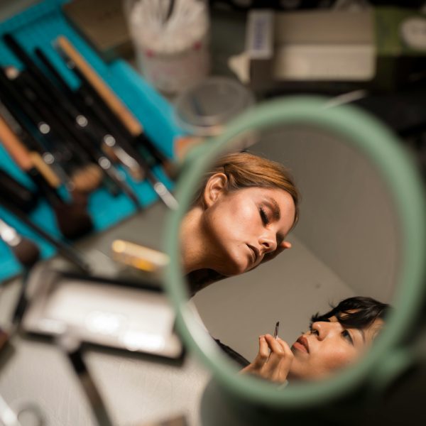 miroir montrant une personne se faisant maquiller